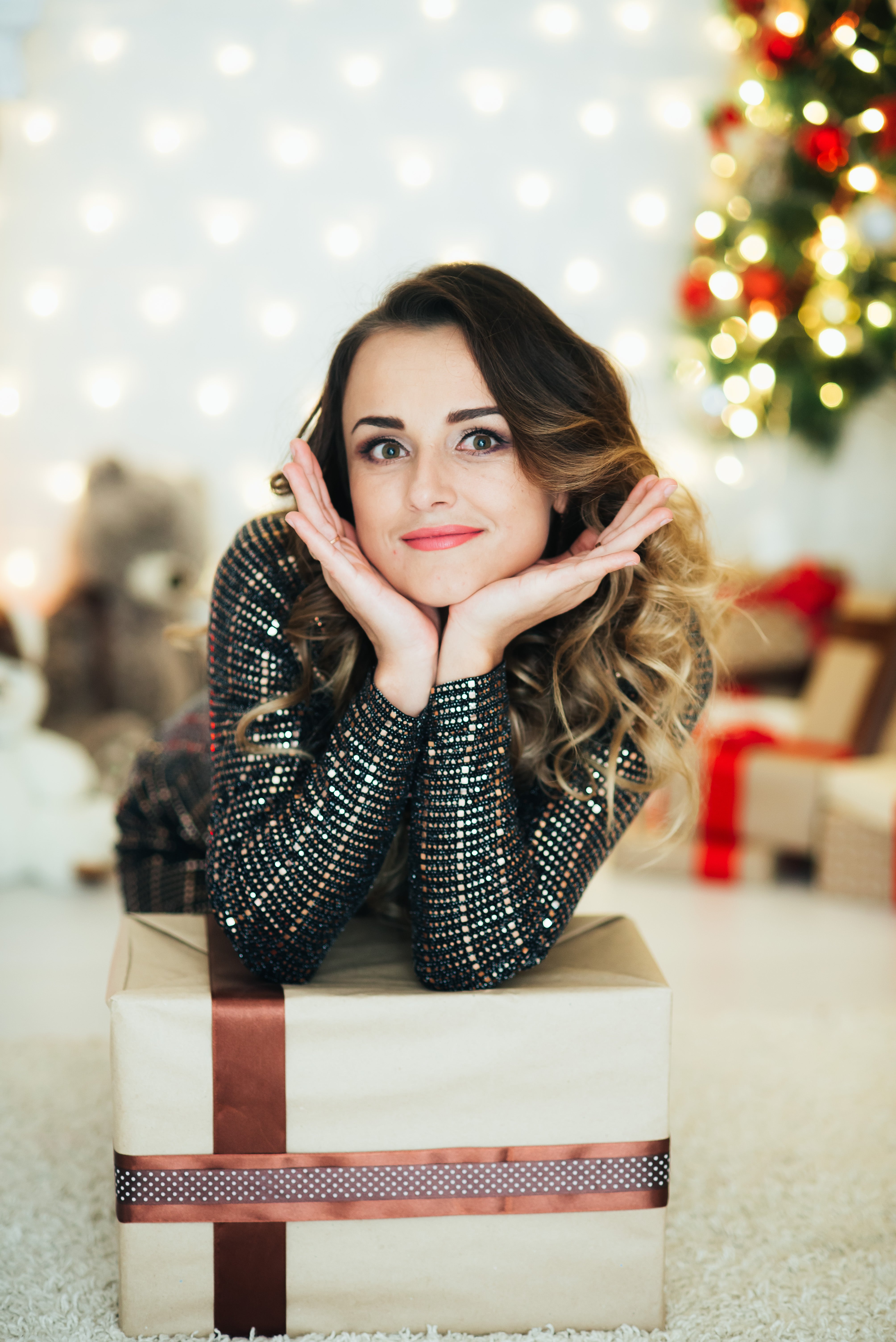 A woman in a Christmas hat holding a Bahaa gift box